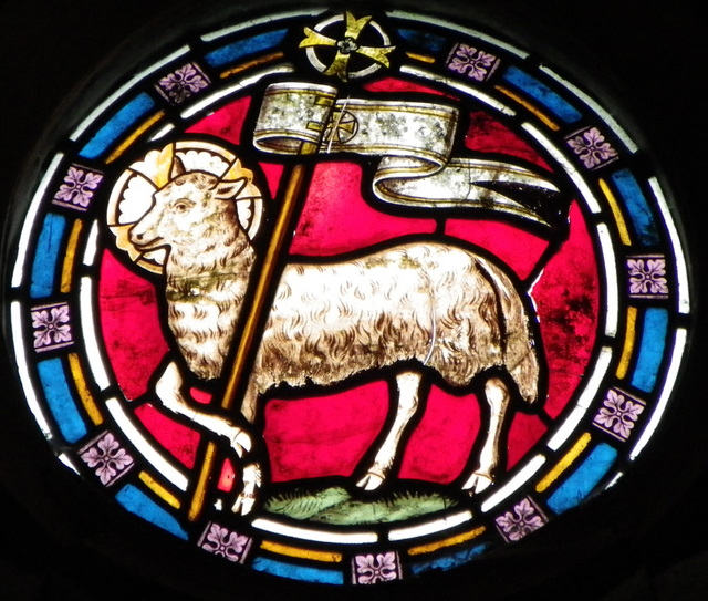 Stained glass window showing the lamb and flag.